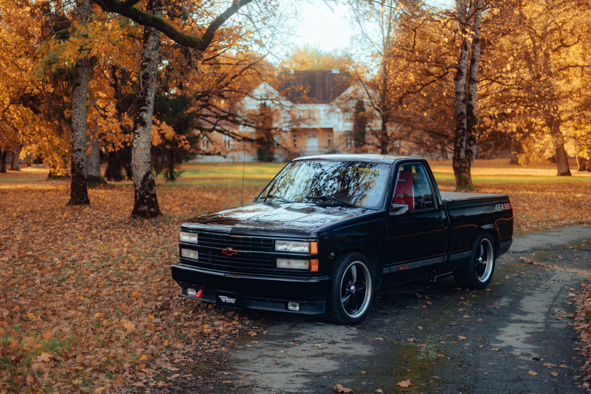 Black Chevrolet C1500 454 SS drag truck in an autumn park
